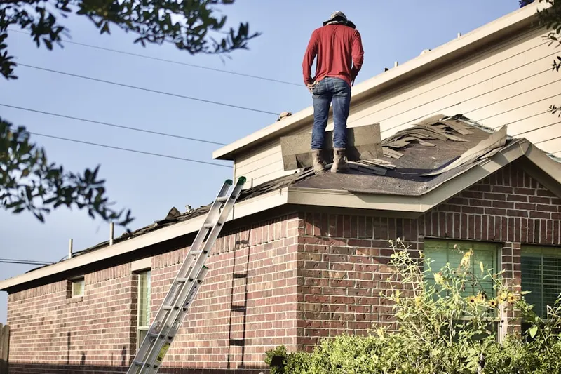 Professional roofer working on a residential roof in Penn Five